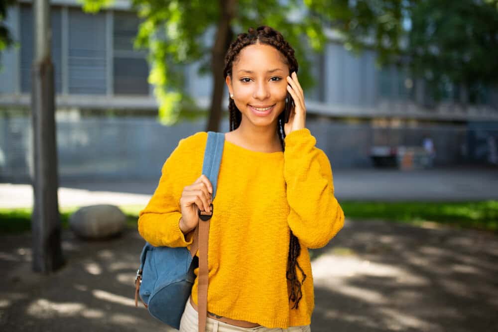 A light-skinned black girl wearing short dookie braids with a few braids that are waist-length or longer.