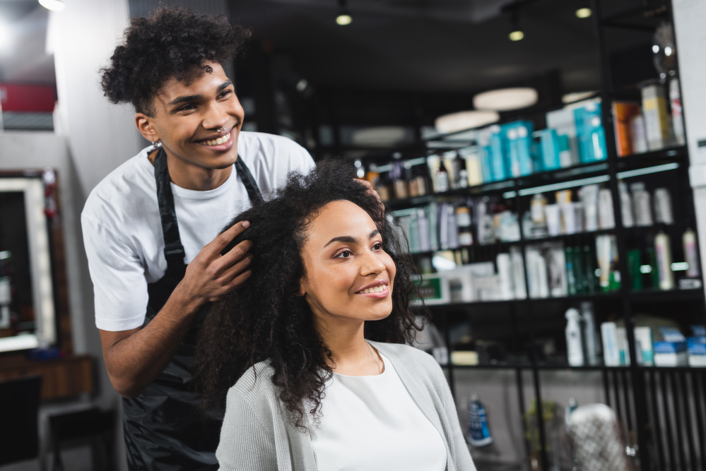 African American female having a consult with a service provider at a hair salon about potential hair color options.