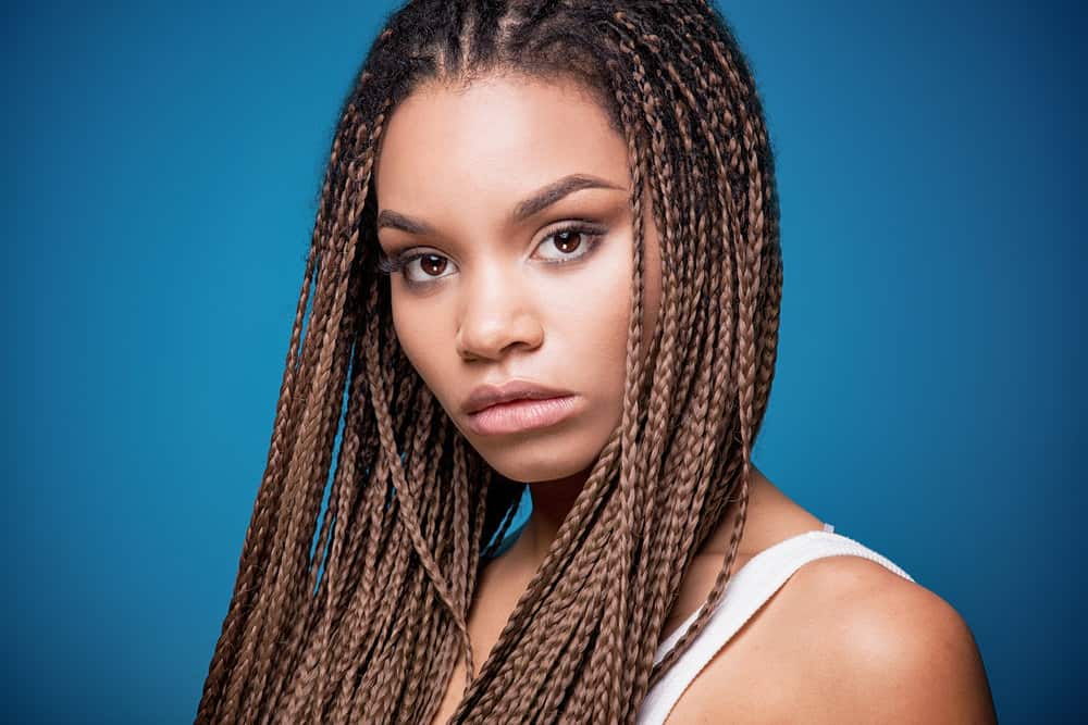 A young black girl with a gorgeous hairstyle wearing thin braids on naturally textured long hair with hair cuffs.