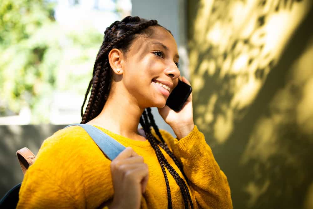 A black girl wearing jumbo braids enhanced with light-brown dark-blonde braiding hair creates an amazing hairstyle.