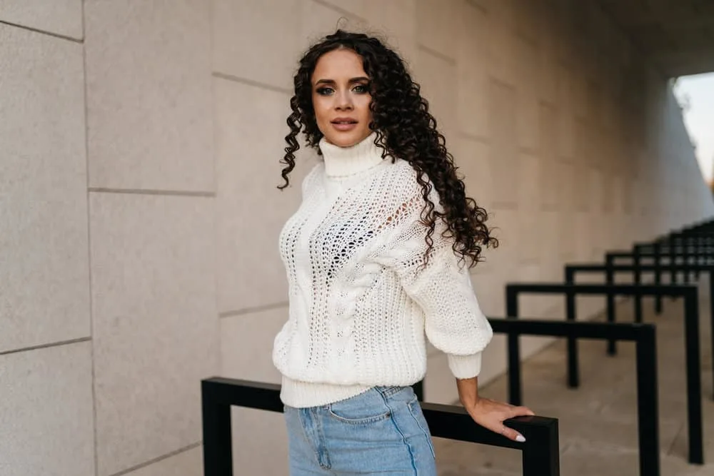 How Much Does a Perm Cost for Girls and Guys at a Salon 4 A stylish girl wearing a casual white sweater is leaving a hair salon after getting a hot perm solution.