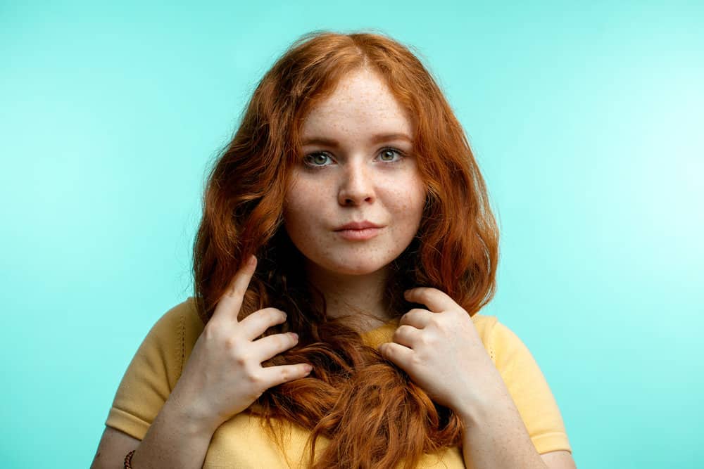 A young woman with bleached hair wondering if using a heat protectant will protect hair from further damage.