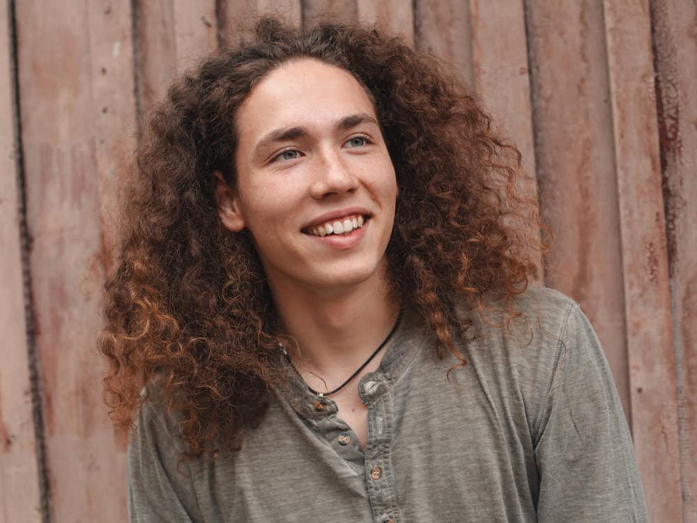 A man with a curly hair type styled with a round brush after being washed and dried with a blow dryer.