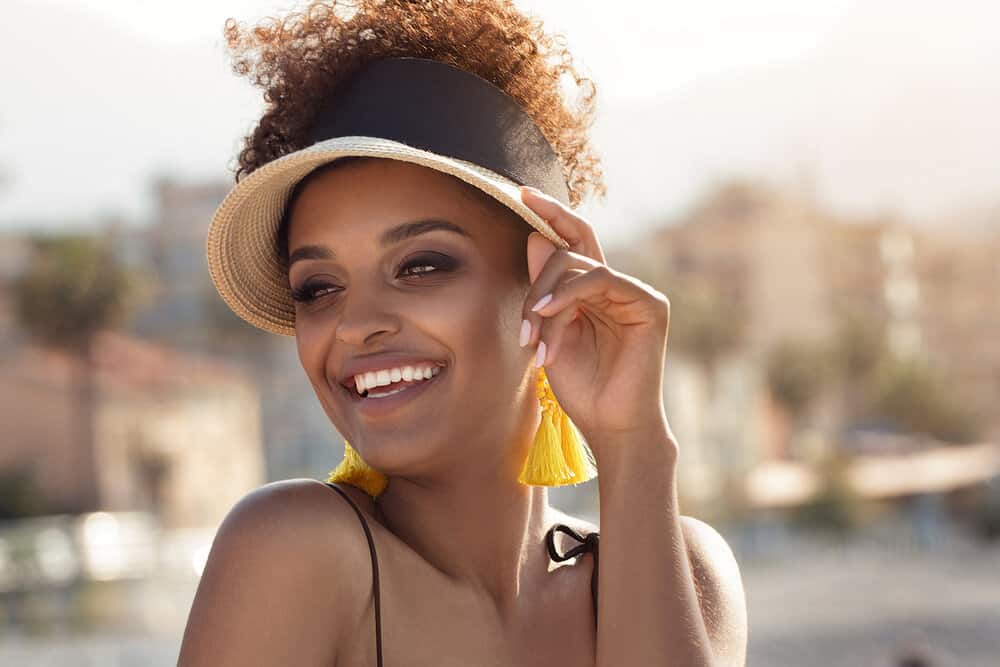 An attractive black female got her lighter-colored hair wet since she didn't wear a swim cap in non-chlorinated water.