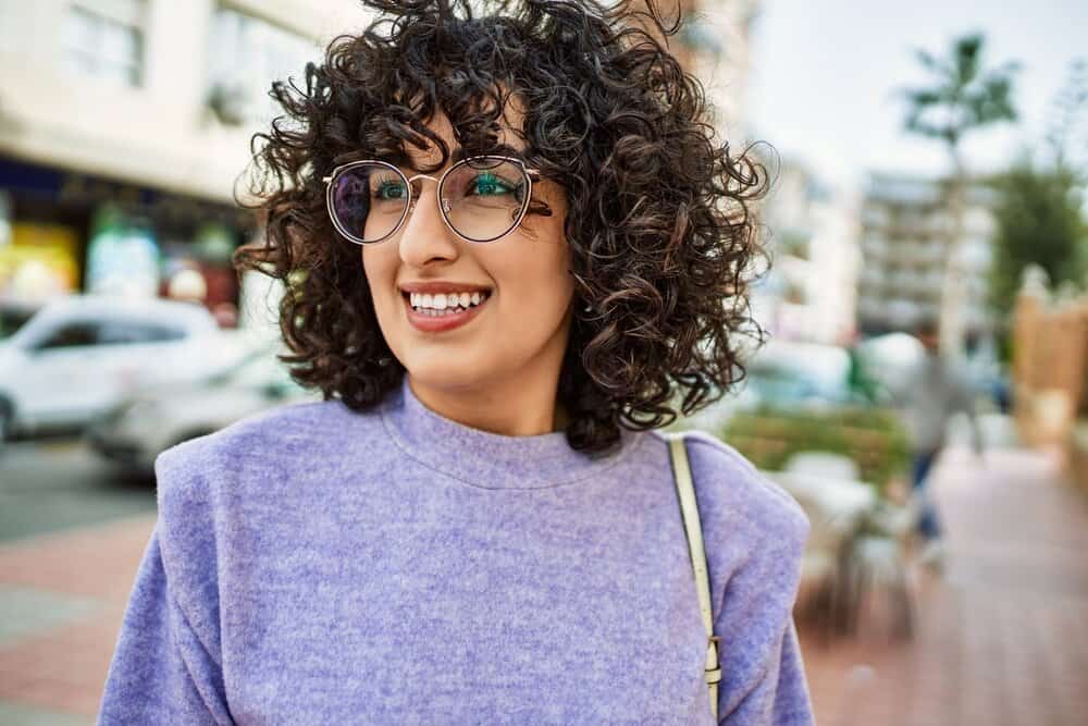 A middle-aged female with unruly hair used a new moisturizing shampoo and hair mask to prevent hair breakage.