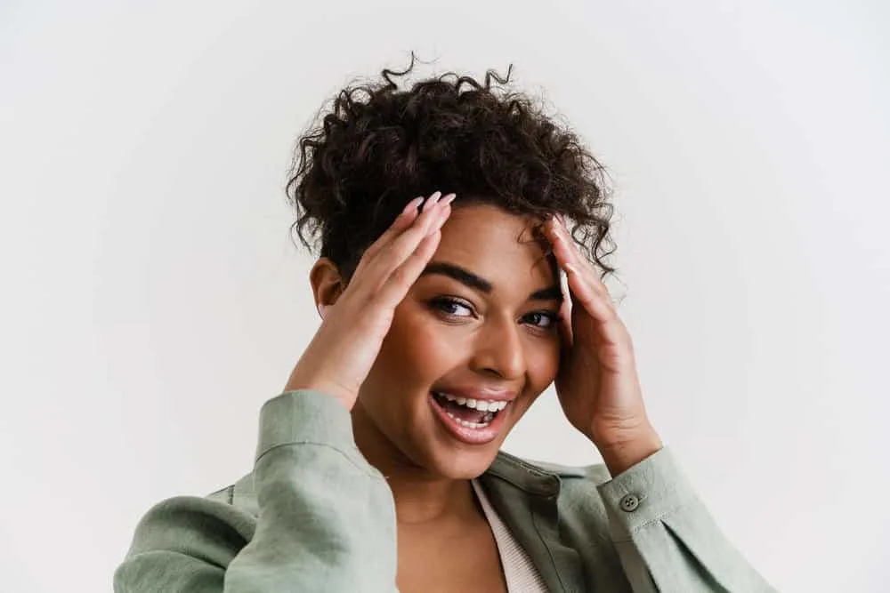 Can Micellar Water Remove Hair Dye From Skin? All Skin Types? 2 An excited young female used baking soda to clean her scalp after applying hair dye to her curly hair strands.