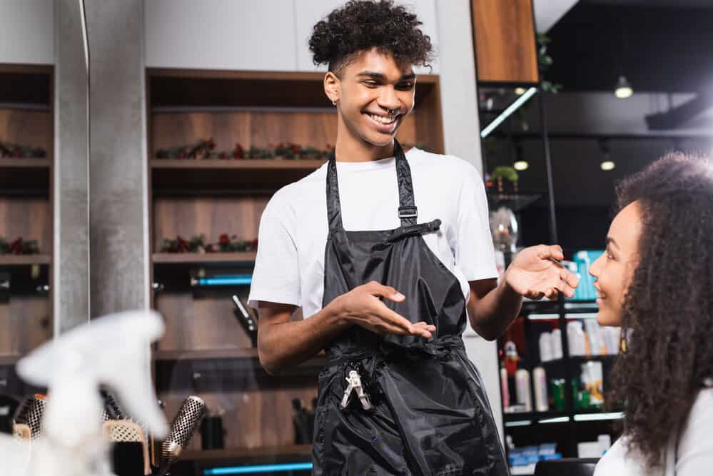 A lady is having a discussion with a salon owner during the holiday season to determine how much is an appropriate holiday tip.