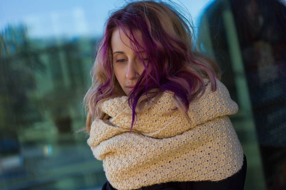 A stylish young white girl with wore gloves to prevent hair dye stains when dyeing her locks purple.