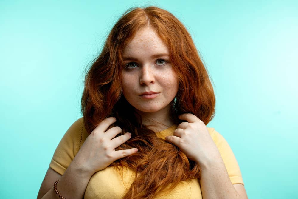 A lady with damp hair after washing hair with shampoo and using a leave-in conditioner on her type 2 fine hair strands.