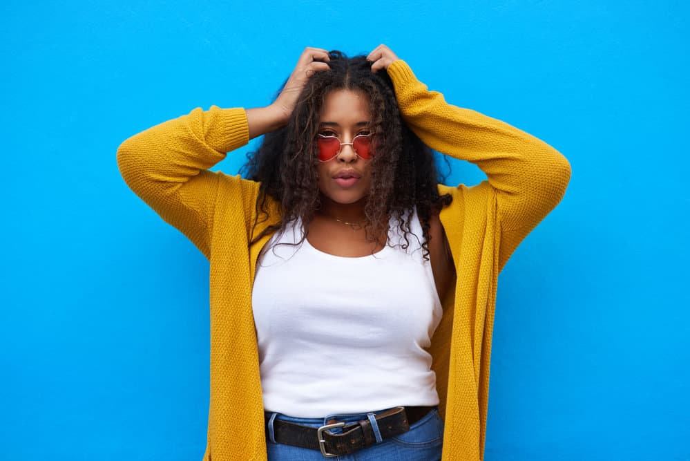 A black girl with kinky hair follicles after using a rosemary hair rinse to stimulate hair growth on her thinning hair.