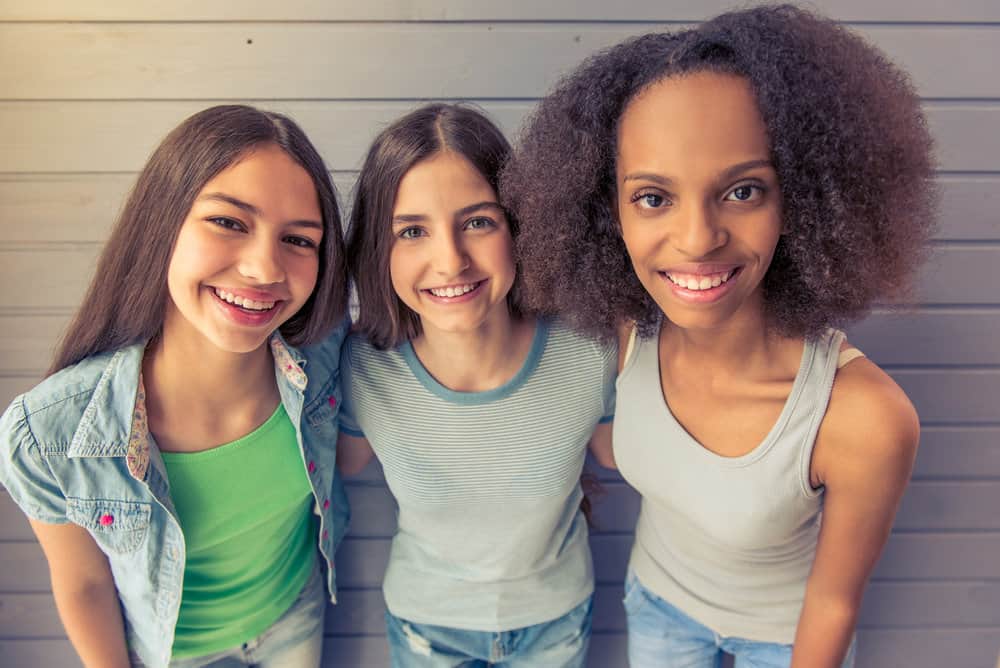 Young girls with alternative hair colors wear styles that range from a classic hairstyle to huge hair with defined ringlets.