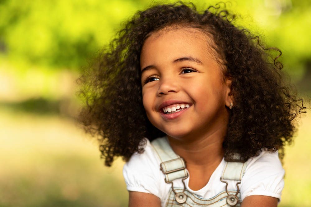 A cute little black girl with type 3 hair strands just had her mother remove two-sided braids on shoulder-length hair.