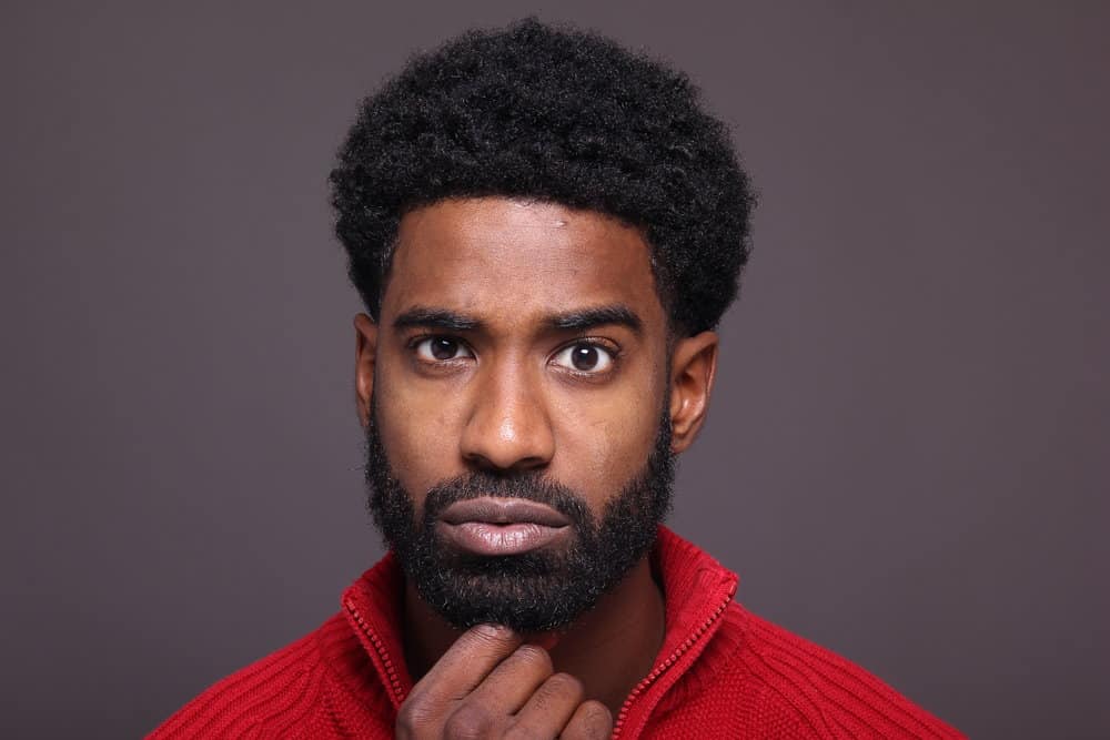 A black male that keeps his hair hydrated and exercises regularly to influence beard growth.