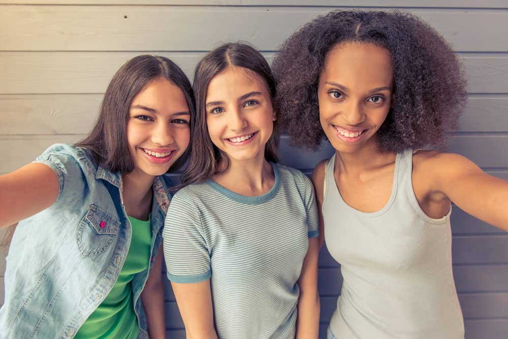 Group of 80s teenage girls wearing various popular hairstyles that are all surprisingly low maintenance.