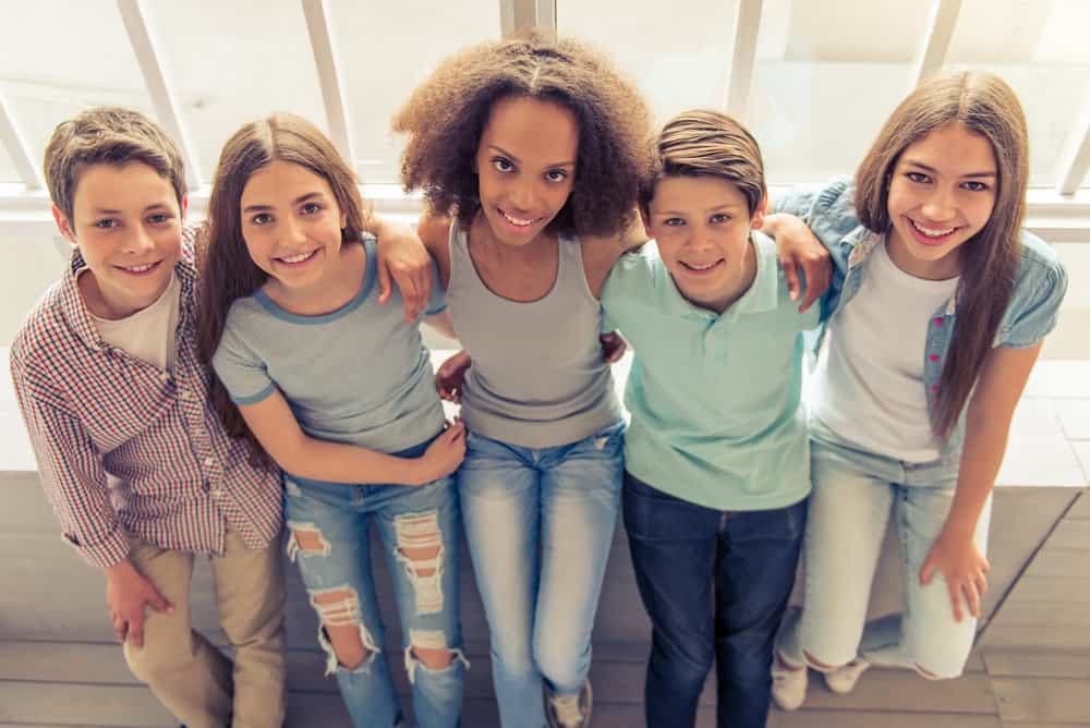 Overhead shot of teenage boys and girls with straight hair, long hair, and a few 80s hairstyles.