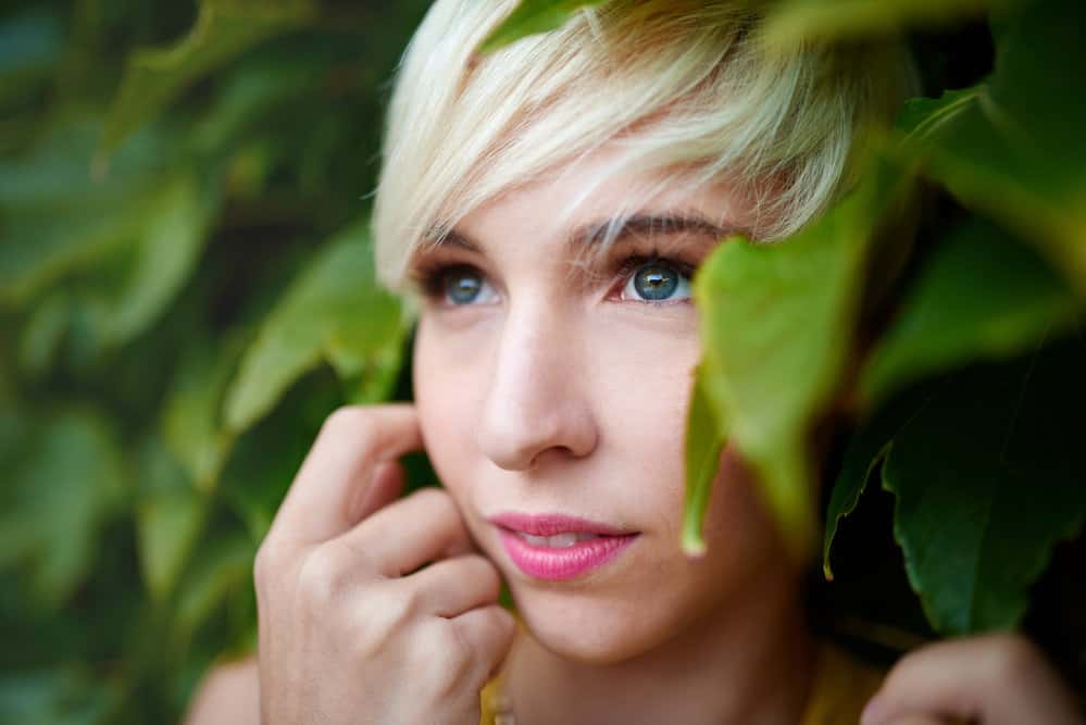 A young millennial woman with short hair due to hair thinning caused by excessive use of flat ironing while styling longer hair.