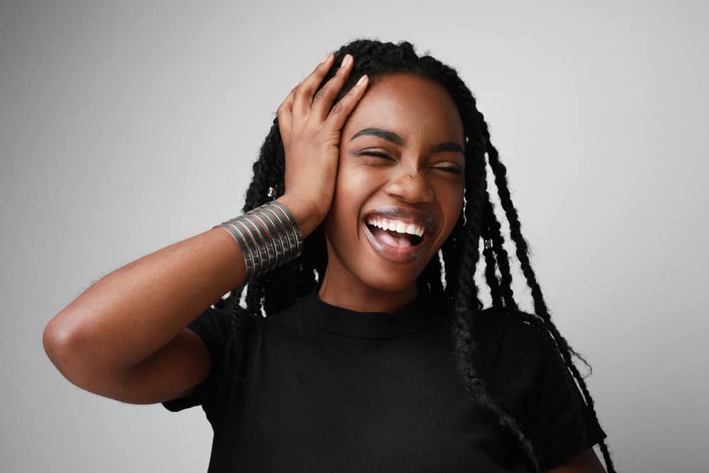 Young black girl with beautiful, healthy hair strands after realizing the benefits of argan and coconut oil.