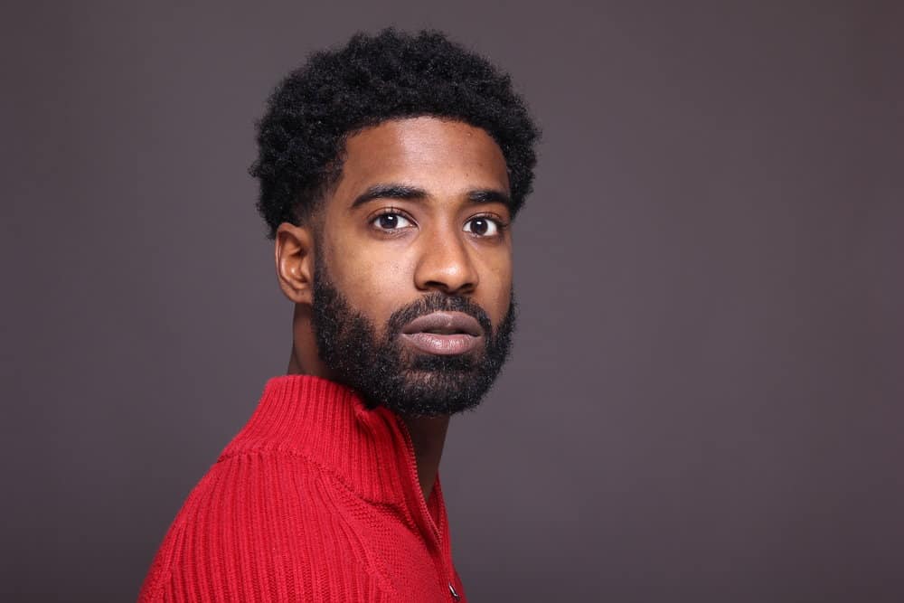 African American male with an amazing beard is using a natural hair regimen focused on regular beard maintenance.