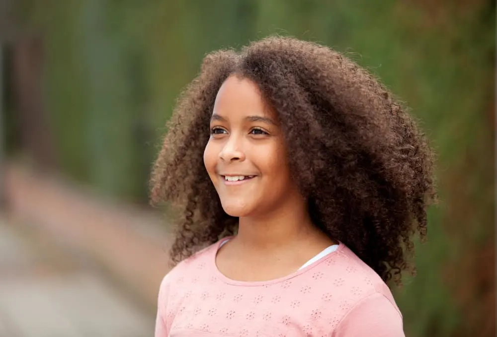 15 Cute, Easy, and Cool Hairstyles for 12-Year-Old Girls 8 A beautiful young 12-year-old child with a beautiful hairstyle styled with a curl cream and human hair extensions.