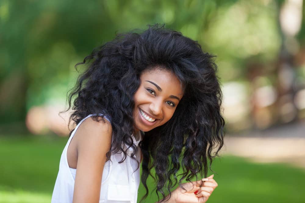 13-year-old little girl wearing a cute hairstyle on her naturally thick hair in a 90s blowout style on long hair.