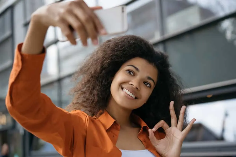 Satin vs. Silk for Hair: What Is Better for Your Hair? 2 A beautiful light-skin black girl with curly hair styled with natural oils and sleeping on traditional bedding materials.