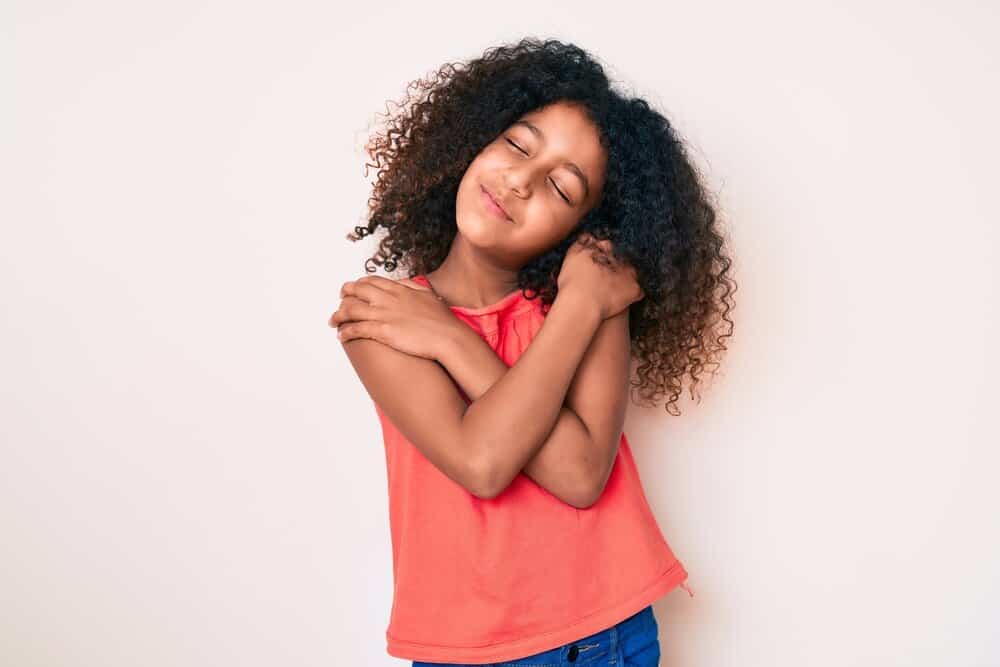 Adorable young black girl wearing a cute hairstyle after removing simple cornrows to a picture day finished look.