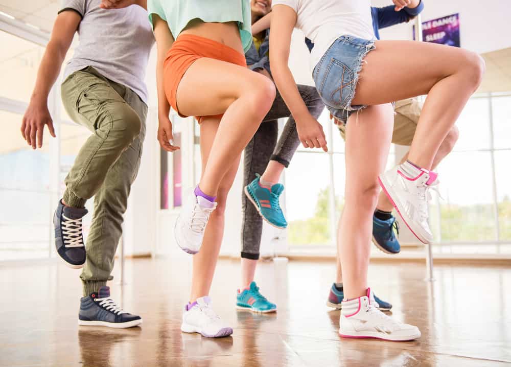 A group of teenage dancers from the 80s with crimped hair, long hair, elastics, and various other styles.