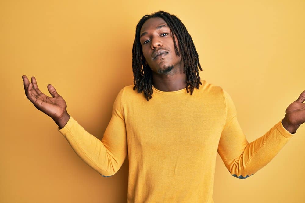 A young African American male with thicker dreadlocks that will form naturally due to his natural hair's texture.