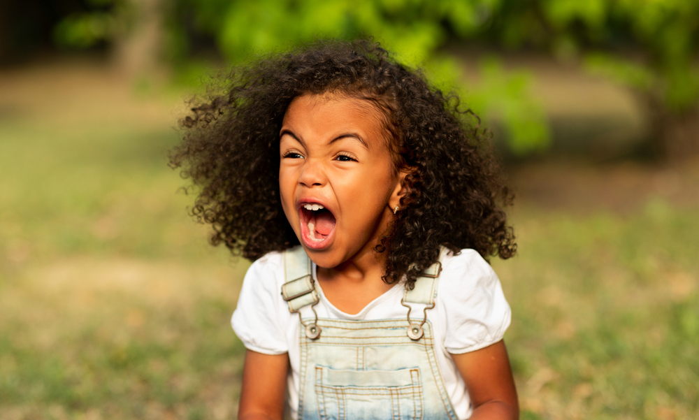 A cute young black girl made a funny face after her mom removed double-sided braids and adorable buns.