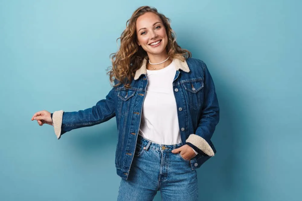 How to Get Butterscotch Hair Color and What Does It Look Like 10 A white lady that has type 3 curly hair with butterscotch shades and platinum blonde hues is wearing casual clothes.