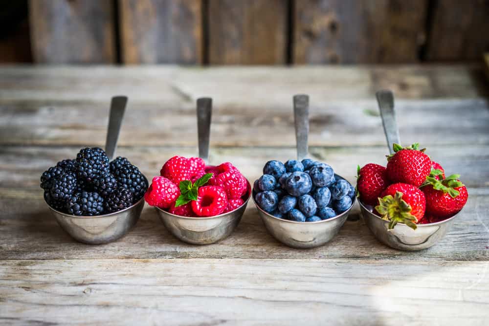A vibrant and juicy assortment of freshly picked berries, including strawberries, raspberries, blueberries, and blackberries.