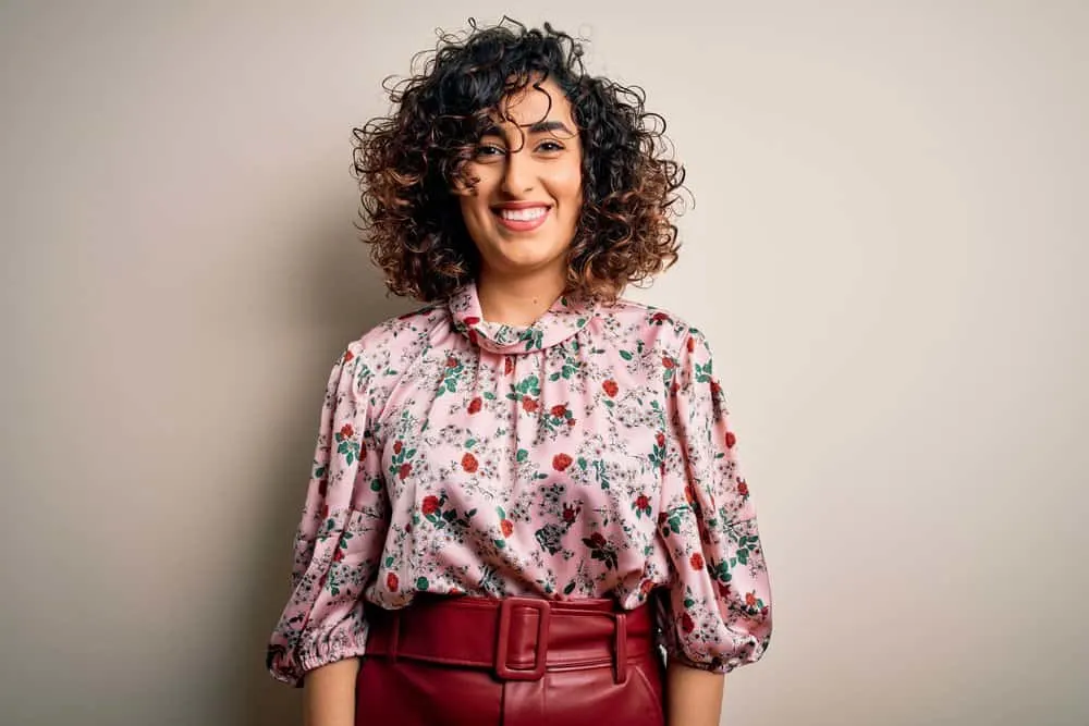 11 Best Hair Color Ideas, Shades, Trends, and Inspo for Women 4 An Arab woman with a curly hair texture has pretty caramel highlights complimenting her rose gold skin tone.