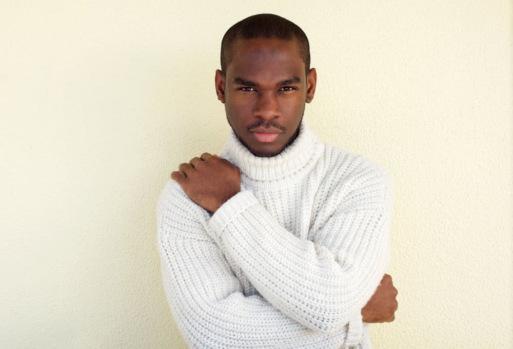 African American male wearing an induction cut keeps his hair trimmed short, but it highlights his receding hairline.