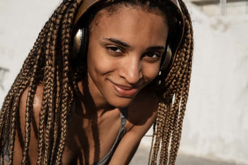 A beautiful black female looks radiant in her super stylish crochet braid style with black and brown hair colors.