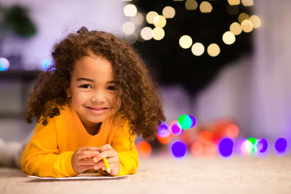 A charming African American kid with a curly toddler hair texture that can be created on long or short hair.