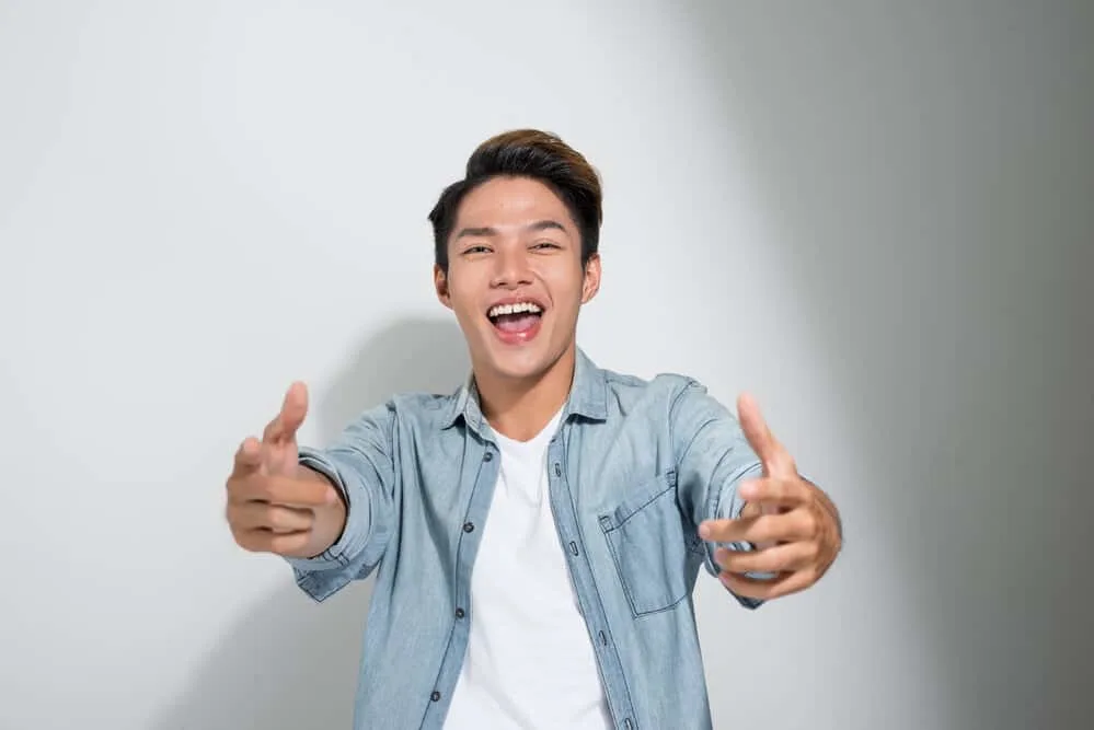 Asian Men Hairstyles: 15 Best Hairstyles for Asian Guys 19 Asian man with recently brushed hair wearing a drop fade hairstyle with longer hair on the top of his head.