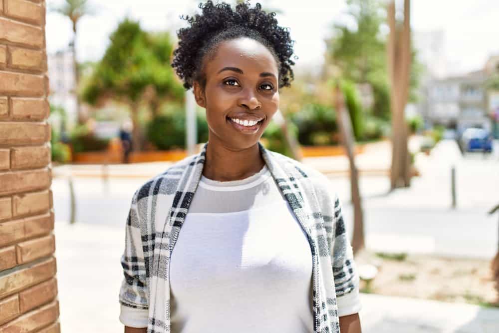 A young African American girl used henna hair dye with metallic salts to color her dark brown natural hair.