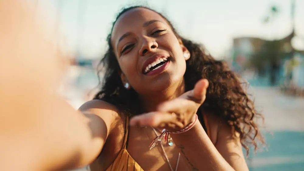How Long to Leave Rice Water in Hair Before Rinsing 11 A dark-skinned black woman with naturally kinky curls that she has straightened with a flat iron.
