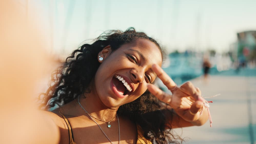 A cute African American lady with type 4 hair that shines like the sun thanks to using a rice water hair rinse for 3 years.