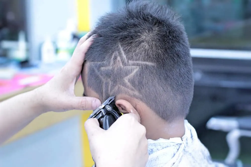 The sharp edges of the double-notch haircut provide a modern and polished look for this young boy's straight hair.
