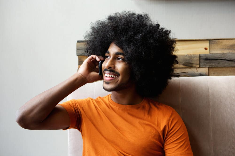 A black male with caramel skin had brittle hair before he started using hair masks to mitigate his poor hair growth.