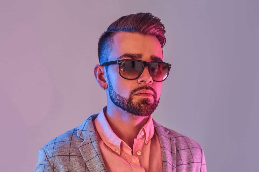 Minimal styling is key for this man's wavy hair with a taper fade, creating a low-maintenance look that turns heads.