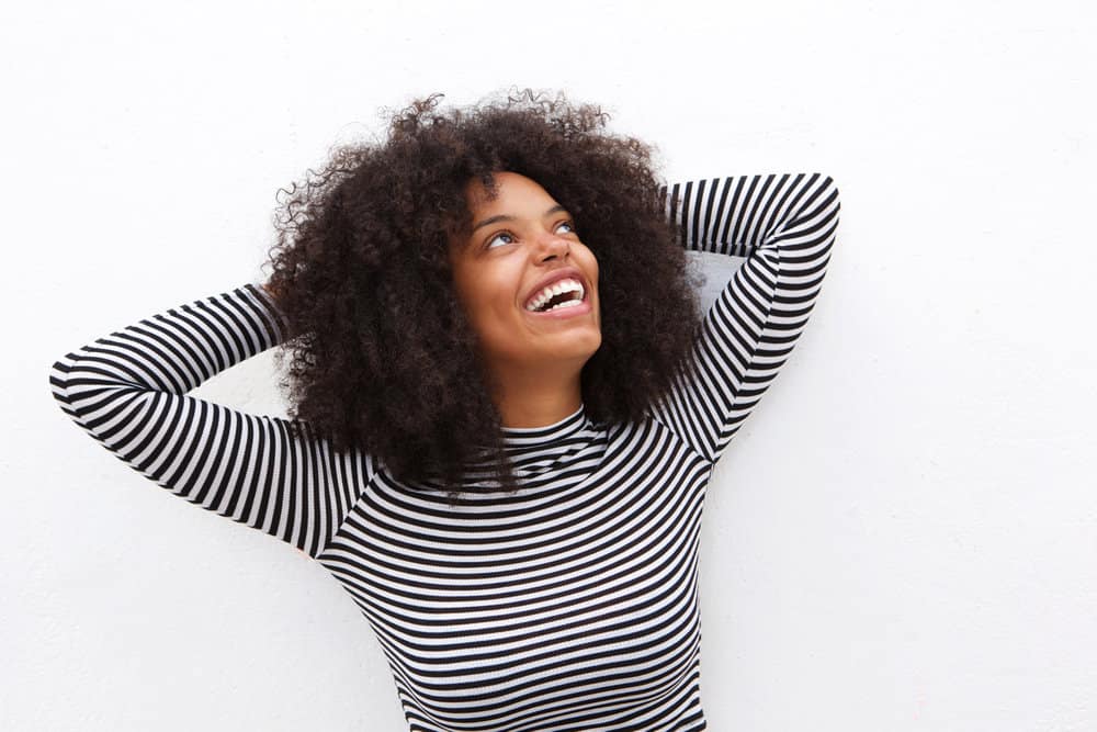 A young African American female is showing off her new curl cut using the Rezo revolutionary technique.