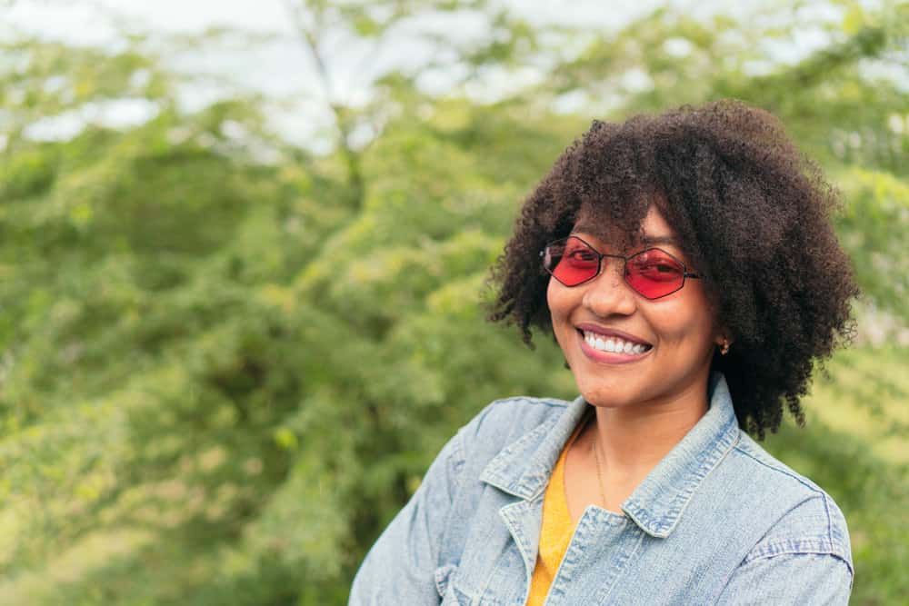 The cute African female with a 4B hair type used the clay mixture to infuse her hair with hydration.