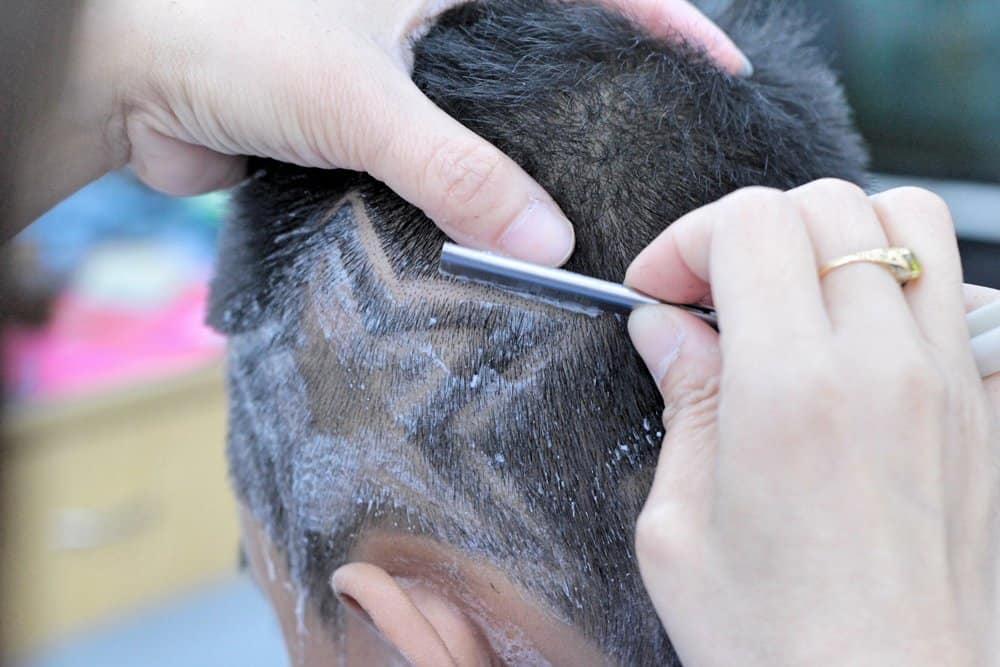 This man with naturally long hair is given an extra touch of style with shaved lines around his entire head.