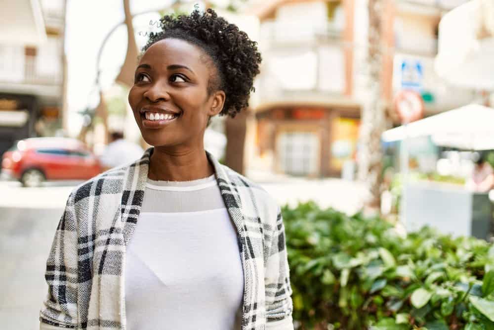 A beautiful African American woman with dark hair used conventional hair dye to transform her brown locks.