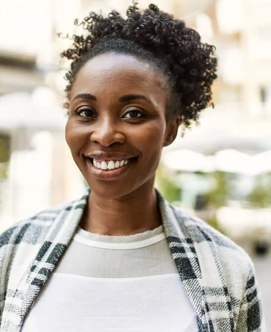 African American female with dark hair after using conventional hair dye to make her brown hair a deep black color.