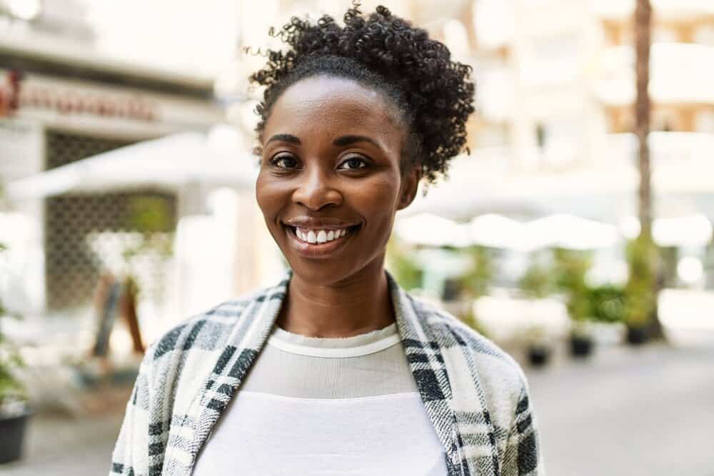 African American female with dark hair after using conventional hair dye to make her brown hair a deep black color.