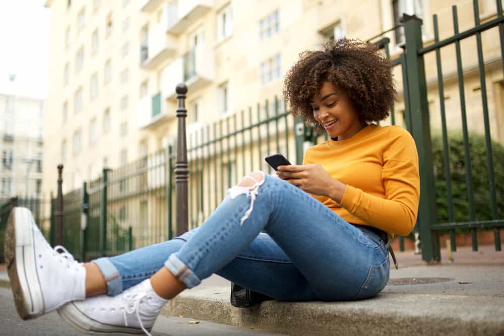 African American female wearing a casual outfit with a balayage twist-out hairdo styled with a leave-in styling product.