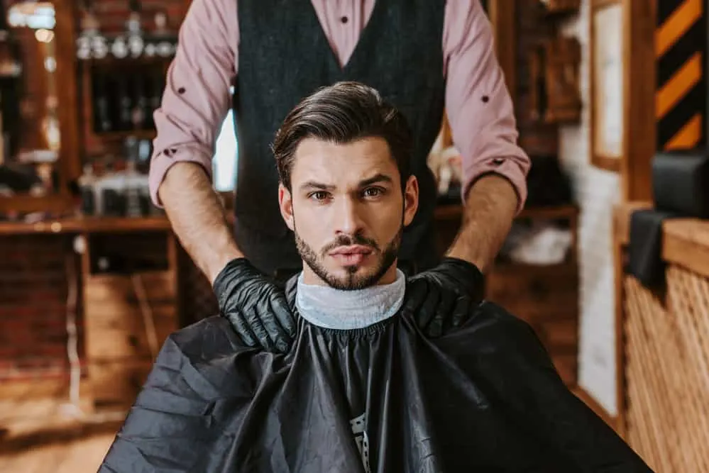 With precision and skill, the barber transforms his client's dark brown straight hair into an Edgar haircut called the #2.